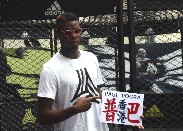 French football player Paul Pogba of English Premier League soccer club Manchester United shows a custom-made Hong Kong minibus emblem reading 'Pogba and Hong Kong' in Chinese, during a promotional event for Adidas Tango League in Hong Kong, China, 1 