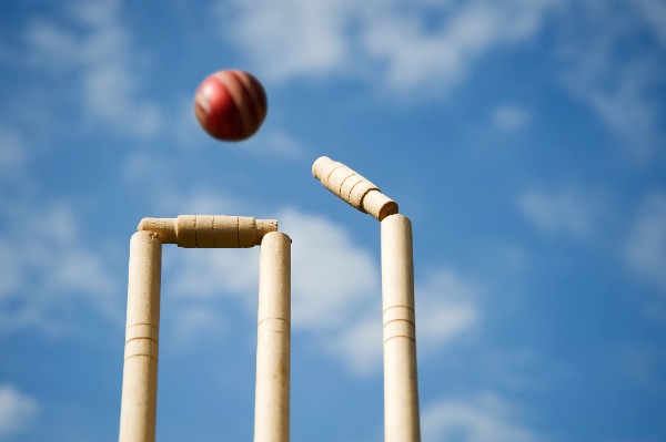 Cricket stumps and bails hit by a ball